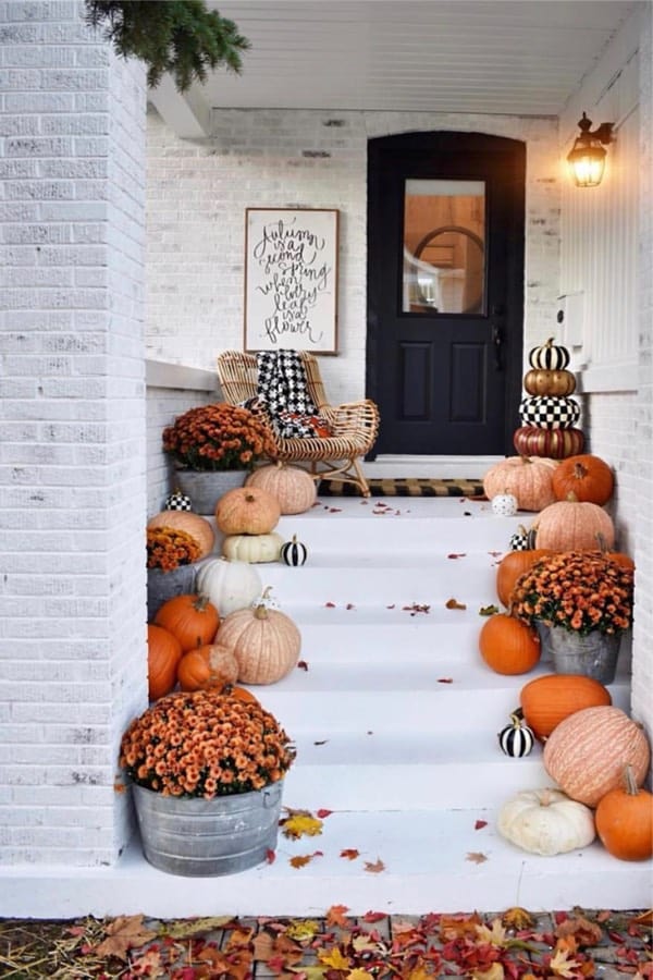 white front porch with pumpkins