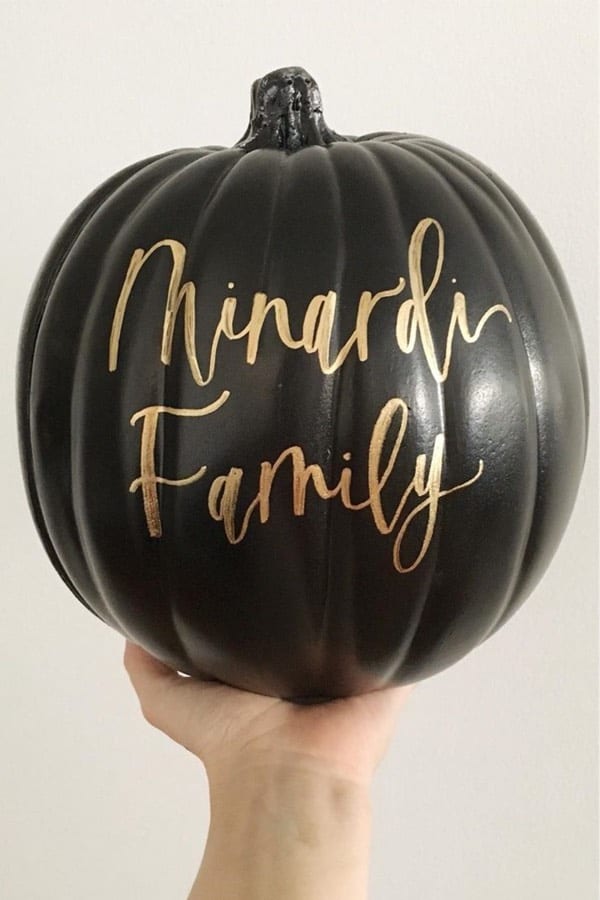 black pumpkin with gold lettering