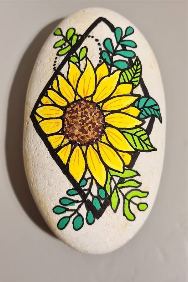 yellow sunflower painted on rock