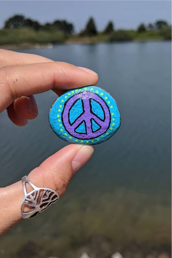 small painted pebble with peace sign