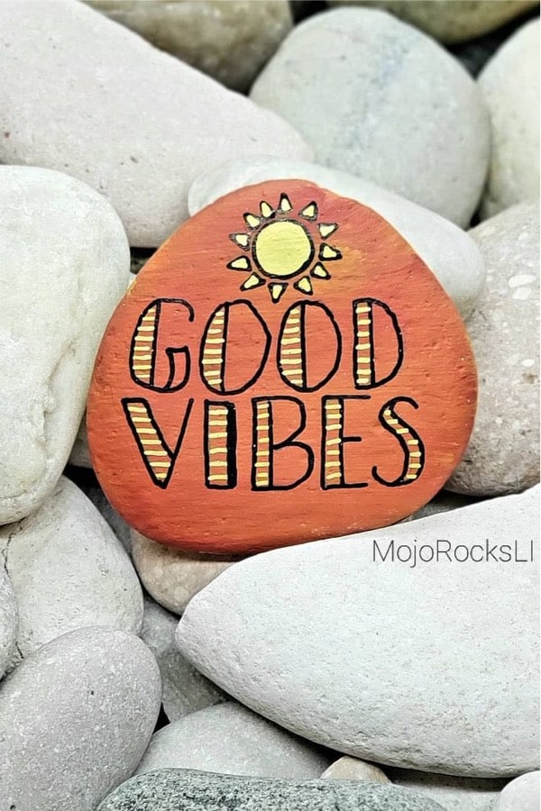 orange and yellow good vibes painted pebble