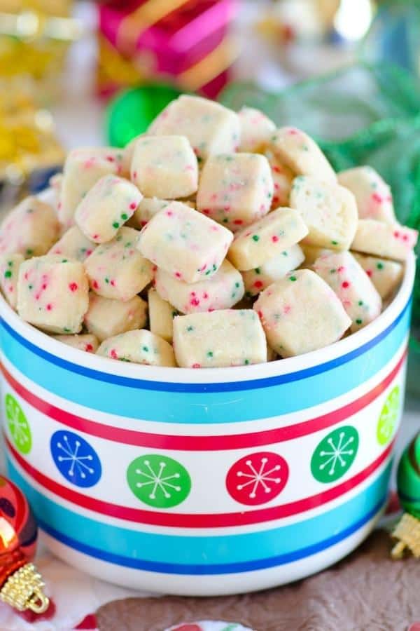 Jingle Bell Bites are small holiday cookies made with shortbread and decorated with green and red nonpareils.