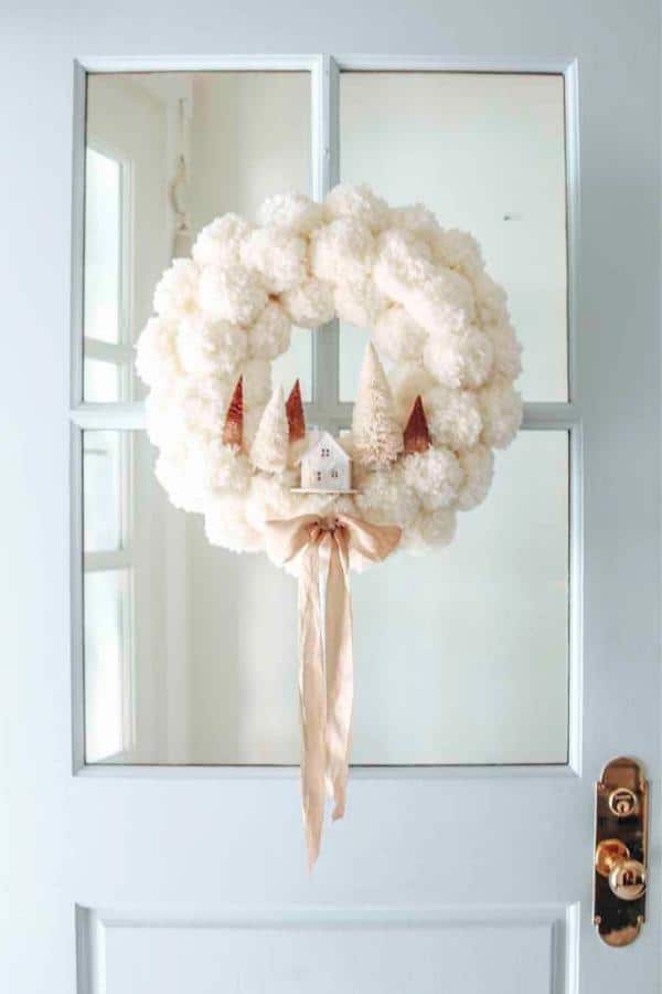 This winter pom pom wreath is an elegant addition to your home that will keep it looking cozy and welcoming during the cold months.