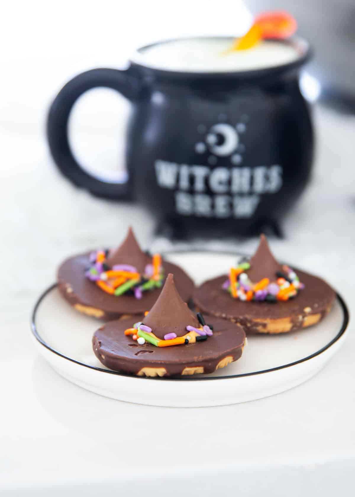 Chocolate witch hat cookies with pointed chocolate peaks and sprinkles