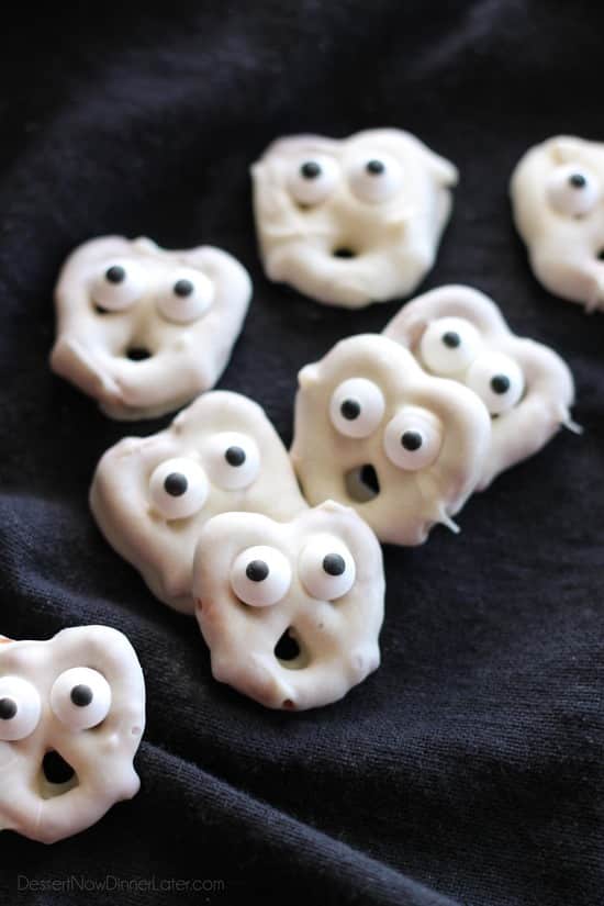 White-coated pretzels with candy eyes arranged as little ghosts