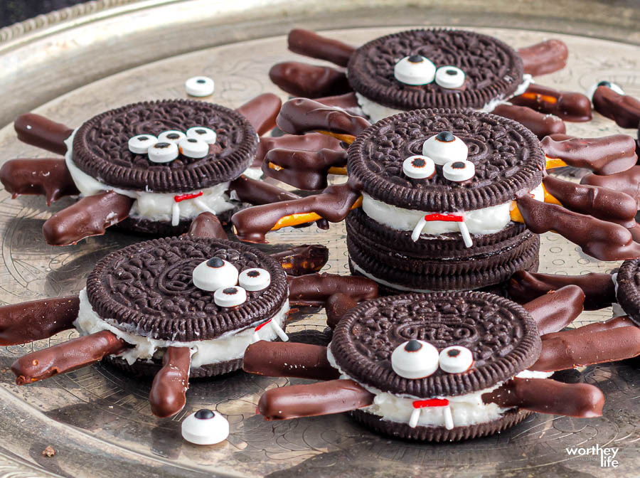 Chocolate sandwich cookie spiders with pretzel legs and candy eyes