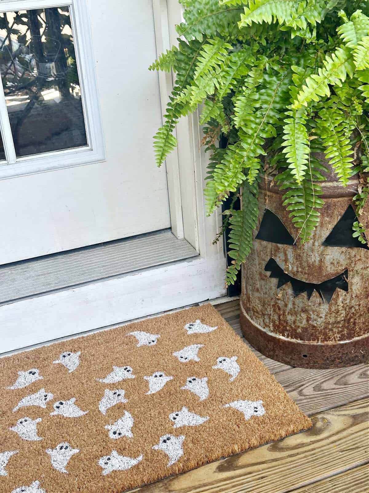 Coir doormat painted with simple white ghosts at a front door