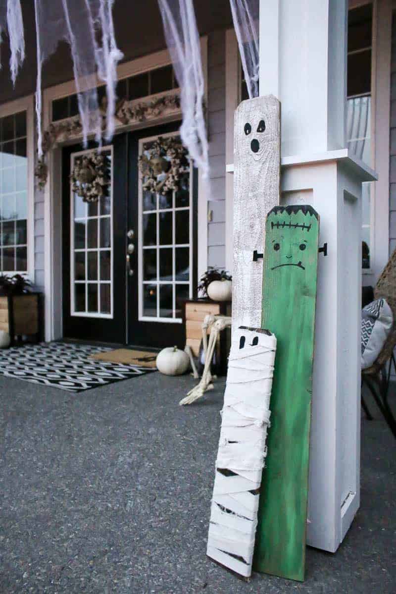 Painted fence board Halloween characters leaning on a front porch