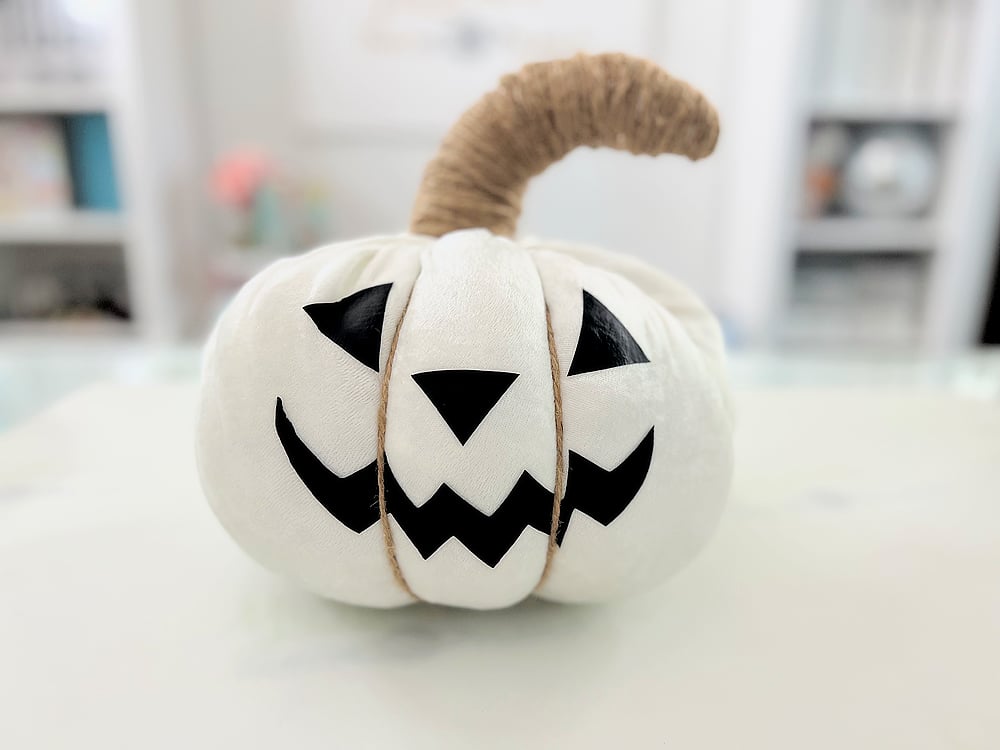White plush jack o lantern pillow with a smiling pumpkin face