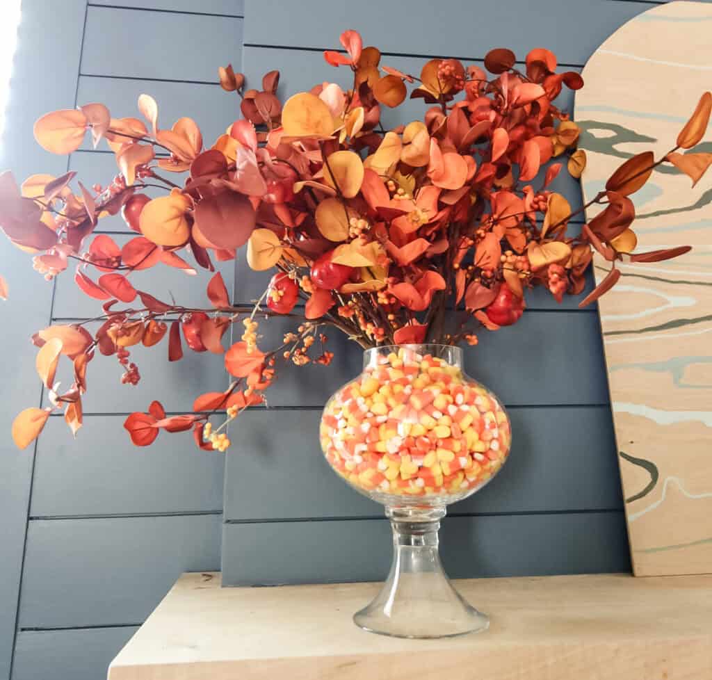 Candy corn layered vase with fall stems arranged as a centrepiece