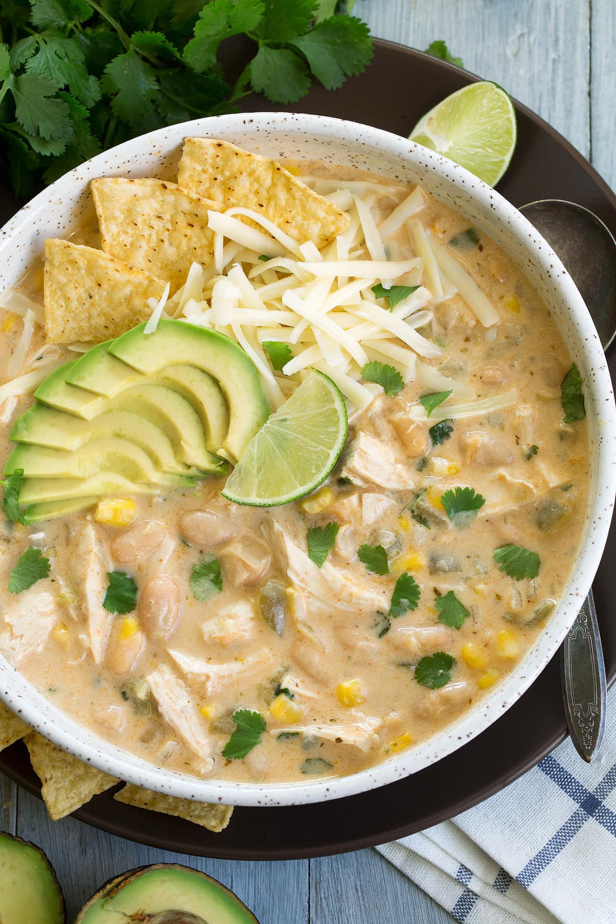 White chicken chili topped with avocado, cheese and a lime wedge