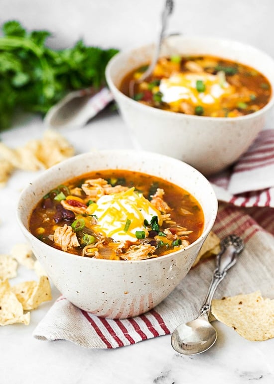 Two bowls of chicken enchilada soup ready to serve