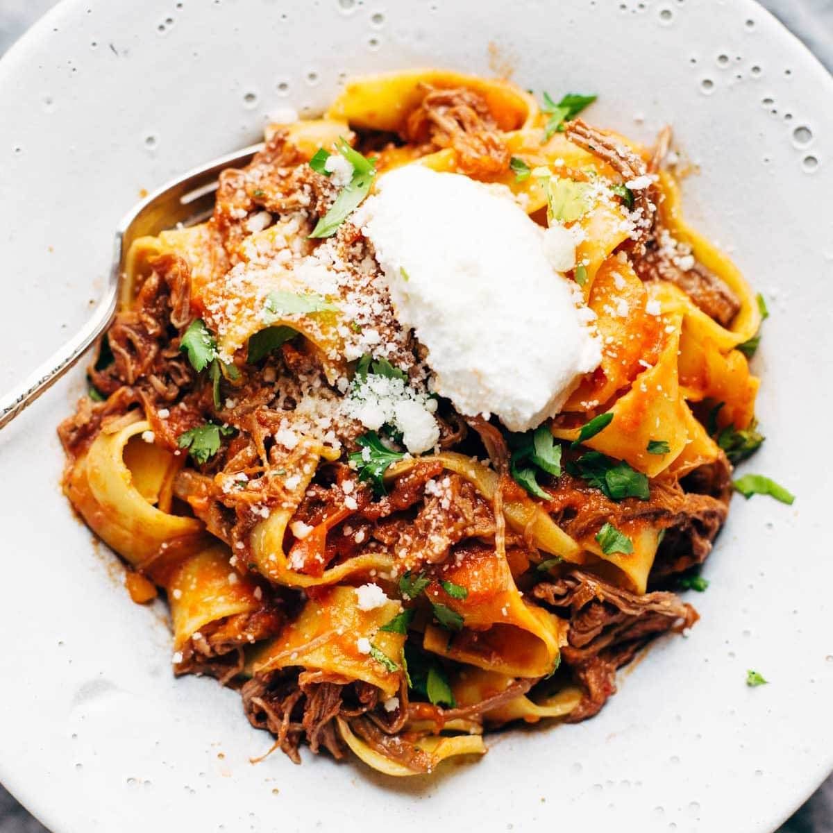 Beef ragu served over pappardelle pasta with ricotta